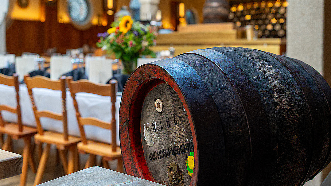 Holzfass mit Hacker Pschorr Bier liegt vor einem gedeckten Tisch im Donisl Traditionswirtshaus