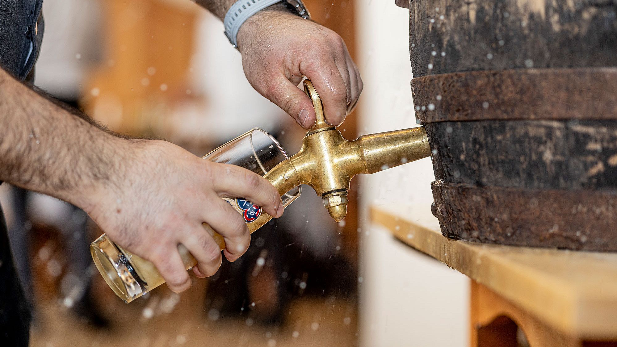 Bier wird frisch vom Holzfass angezapft